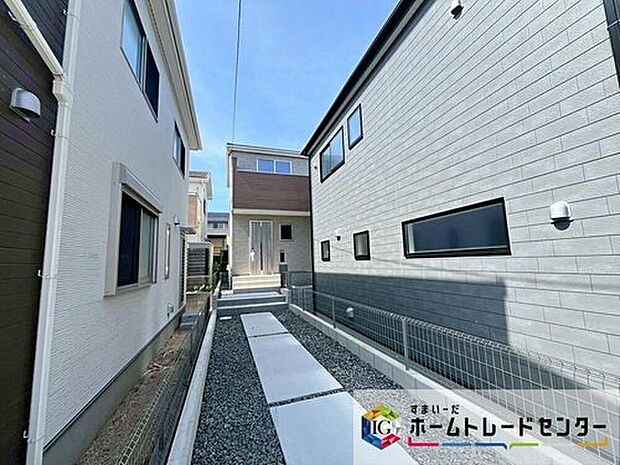 【アプローチと建物外観(分譲地)】建物間の玄関アプローチと歩行スペースが確認できる外観写真です。土地面積154.36m2、並列2台駐車可能な敷地です。