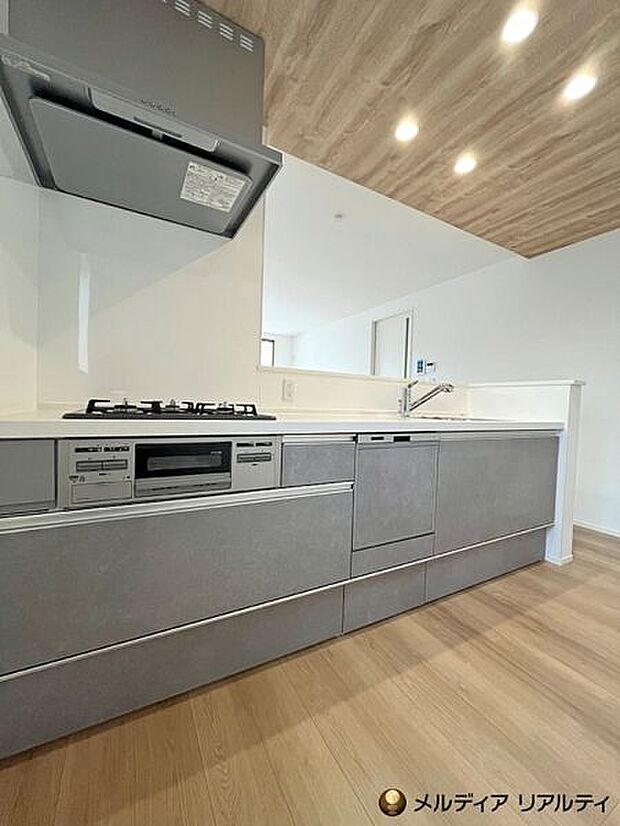 【キッチン】キッチン部分の天井にはアクセントを採用。木目ならではの温かみを添え、LDK空間をぐっと引き締める洗練されたデザインに仕上げました。