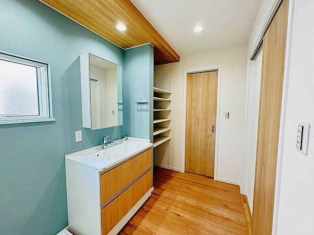 【洗面台・ランドリーラック 施工例】洗面室は広く気持ち良い癒しの空間となっています。バスタオルや洗剤などをストックしておくのに便利ランドリーラックは、物の大きさに合わせて高さが調節できる可動棚なので大変便利です。