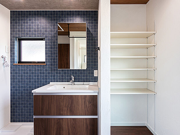 【ランドリーラック　1期施工例】浴室と洗面室に合わせて2つの物干しを設置。またバスタオルや洗剤などをストックしておくのに便利なランドリーラックがあります。物の大きさに合わせて高さが調節できる可動棚なので大変便利です