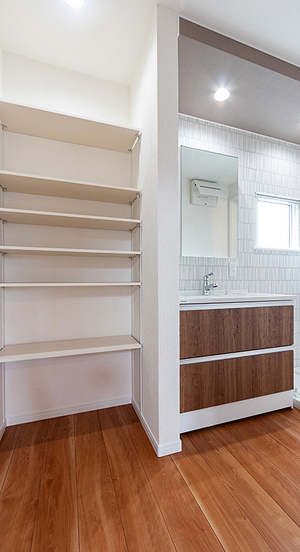 【ランドリーラック】洗面室には物の大きさに合わせて高さが調節できる可動棚を設置。タオルやボディーソープのストック、着替えなど家族の日用品がきれいにしまえ、使うときもさっと取れるので大変便利です。