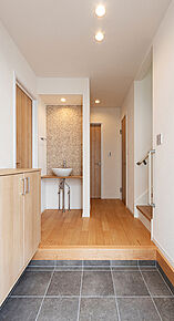 メインの洗面室とは別に、玄関を入ってすぐのところにセカンド洗面台を設置。コロンとしたかわいらしい小型の洗面ボウルは、外から帰ってきてすぐに手洗いとうがいができるので、小スペースながら機能的！ウイルスはドアノブから感染につながることもあり、風邪や感染症などの予防になり、いつでも清潔な状態で室内へ。遊んで帰ってきた子供も自然と手洗いが習慣化され、来客時にはわざわざ洗面室を使って頂かなくて済みます。また、壁に施されたモザイクタイルは、遊び心が溢れるデザインでインテリアとしても楽しめると人気です。 