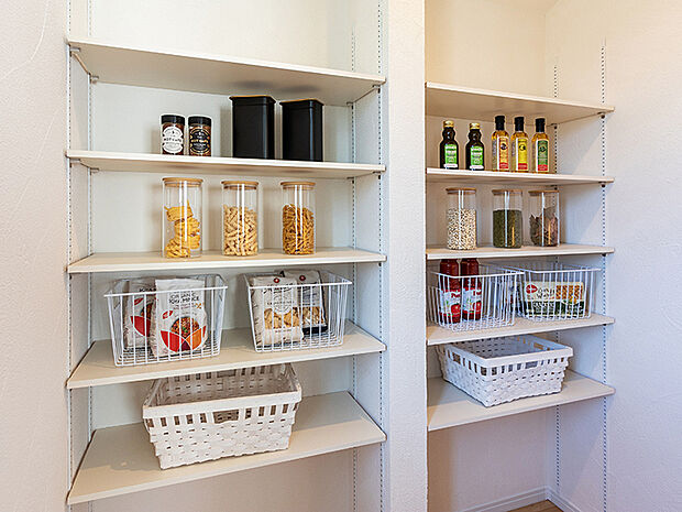 【パントリー（施工例）】食料品のストックや食器、調理器具などをすっきりと収納できるパントリーを全棟に設置。食品の在庫も「見える化」されて、分かりやすく取り出しもスムーズにできます。壁は色彩豊かなアクセントクロスで素敵に演出。
