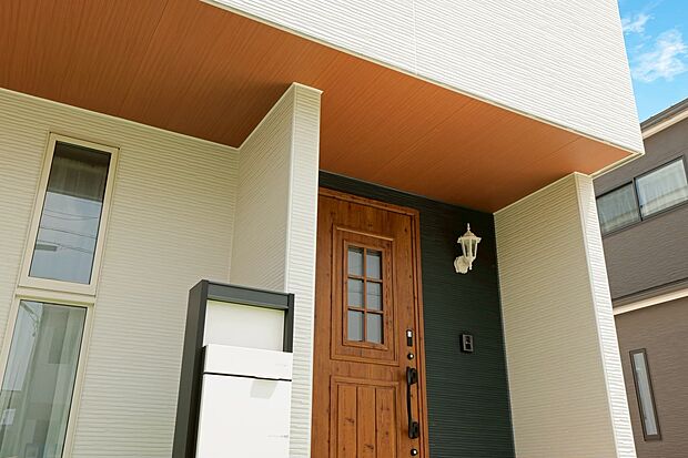 【軒天】白を基調とした爽やかな外観に、玄関まわりのアクセントが映えるサーフスタイル。木目調の軒天がナチュラルな温もりを添え、洗練されたデザイン