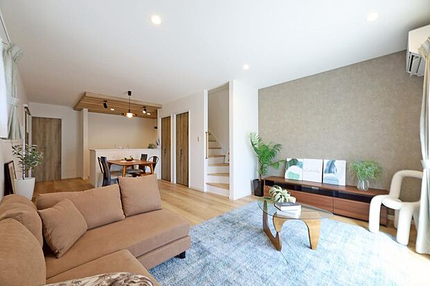 【LDK※現地写真】壁で仕切ることなく、天井や壁のデザインでリビングとダイニング・キッチンを緩やかに区別。家族が常に繋がりを感じながら、上質なインテリアの中でゆったりと過ごす、そんな暮らしを叶えます。