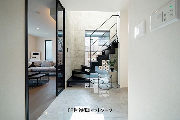 【内観】【プラン例　建物価格2480万円　建物面積100m2】吹抜けと鉄骨階段が開放感を演出する玄関ホール。室内にいながら中庭とのつながりも感じられる設計です。