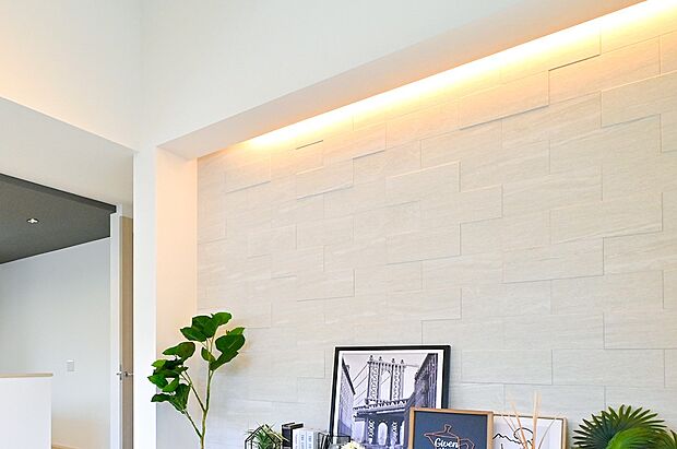 【リビング】【アクセントウォール・間接照明】深みのある素材に柔らかな光が陰影を添え、上質さを演出。(2号棟)※撮影画像の家具は異なる場合があります