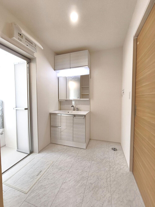 【洗面所】浴室同様、ホワイトカラーでまとめられた洗面所は、横幅が900mmワイドの三面鏡付きで朝の身支度もラクラク。吊り戸もあり収納スペースにも困りません。