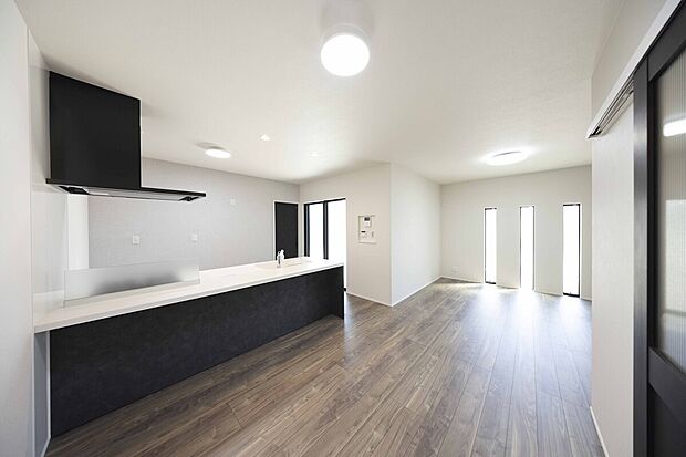 【LDK】モダンな印象を与えるグレーのキッチンと木目のフローリングがスタイリッシュな雰囲気を演出しています。多数設けた窓から明るい日差しが差し込み明るく心地よい空間となります。