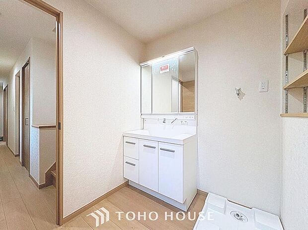 【洗面台・洗面所】白を基調とした清潔感溢れるデザインの洗面化粧台です。三面鏡の裏側や足元のキャビネットなど、収納豊富で実用的な洗面空間です。