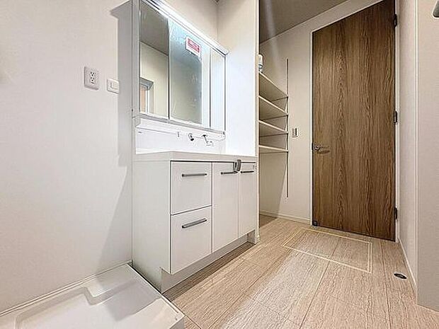 【シャワー機能付きの洗面台】白を基調とし、機能的でスッキリとした印象の洗面台になっています。