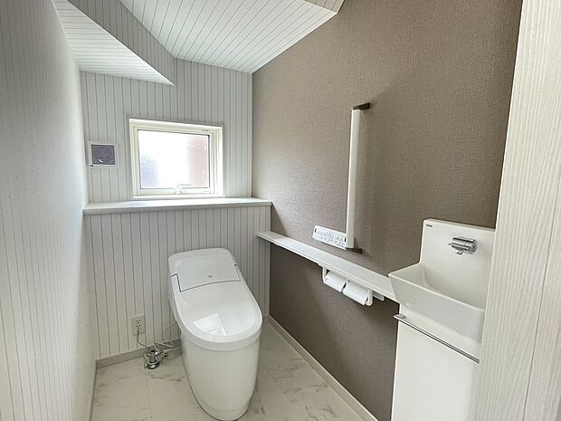 【1Fトイレ】1階トイレは節水型の多機能便座です。広々しているので圧迫感のないトイレになっています。手すりやバリアフリー構造など将来的にも安心して使用できるものになっています。独立した手洗いもご用意しています。