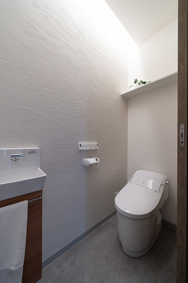 【【2階・トイレ】】LDK階のトイレはローシルエットタイプでスッキリとした印象に。独立した手洗い器を設置しています。ホワイトのクロス×コーニス照明が、洗練された空間を演出します。