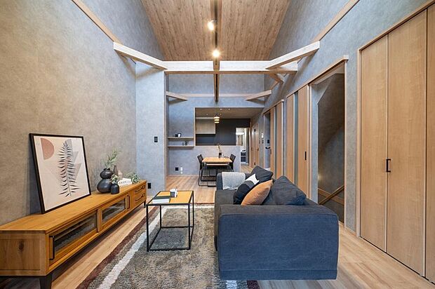 【【本分譲地に建築可能な建物プラン例】】マットな質感のクロスをベースに、温もりを感じられる木目を随所にあしらったLDK。見せ梁が意匠性を高めています。《分譲地外:建物面積95.28m2、建物価格1628万円》