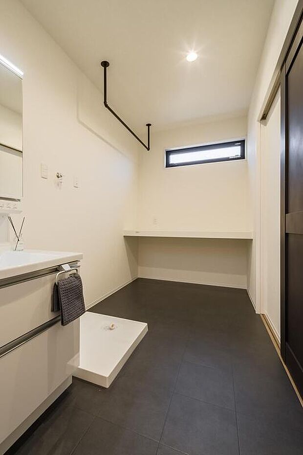 【【本分譲地に建築可能な建物プラン例】】ハンガーパイプとカウンターを備えたゆとりある洗面室。洗濯から室内干し、アイロンがけなどの作業がここで完結します。《分譲地外:建物面積98.82m2、建物価格2072万円》