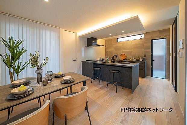 【プラン例　建物価格2300万円　建物面積100m2】対面キッチンと緩やかにつながるダイニング空間。間接照明がやさしく広がり、食事の時間を上質に演出します。