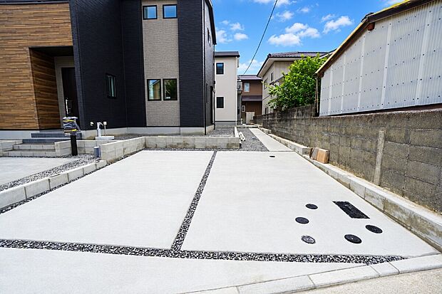 【2号棟　駐車場】駐車スペースは道路沿いにあり、2台まで並列駐車できます。急な来客時やお子様が成人して車を所有するようになっても安心です。