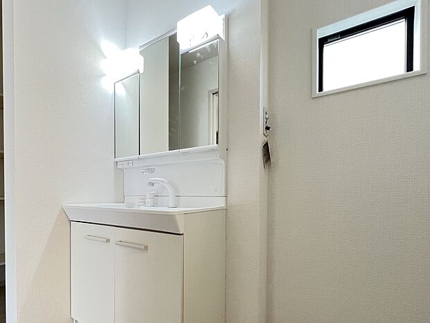 【同仕様写真(その他内観)】三面鏡仕様の洗面化粧台　脱衣所には収納スペースも完備(1号棟同仕様)