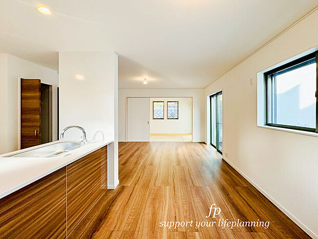 ～5号棟～リビングに降り注ぐ明るい陽射しがそのままキッチンにも柔らかく降り注ぐ明るい印象のキッチン廻り。リビングとキッチンの間に壁を設けてないフルオープンタイプですので、空間に一体感を感じられます。