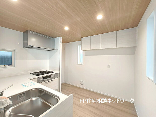 機能性とデザイン性を兼ね備えた嬉しいL型キッチン。背面には備え付けの吊戸棚があり、収納スペースもしっかり確保しています。