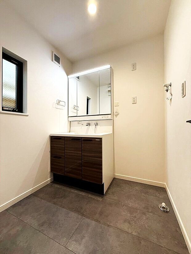 【洗面室・洗面台】鏡の裏に収納棚を確保した三面鏡を採用。化粧品や歯ブラシなどを機能的に収納。また、三面鏡の本当の利点は三枚の鏡を合わせることで、頭の側面や背面が見れること。