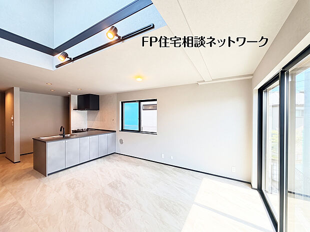【吹き抜けの開放感と、洗練されたリビング】太陽のやわらかな光が差し込む開放的なリビング。2階部分の窓から1階へと光を取り入れ、快適で心地の良い空間を演出してくれますね。
