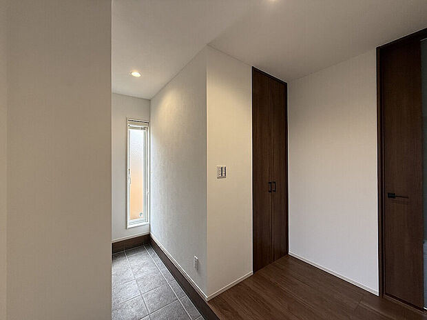 【玄関ホール】土間と室内をゆるやかにつなぐ、光が差し込む明るい玄関ホール。