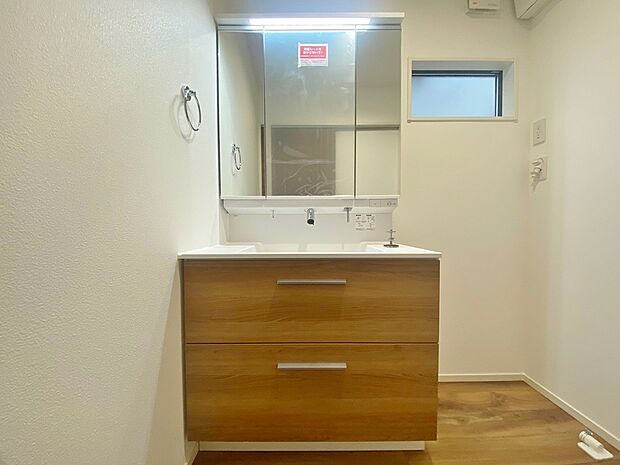 【2号棟　洗面脱衣室】ゆとりの洗面スペースで朝の身支度も快適スムーズ。
鏡の裏にはたっぷりと収納スペースを標準装備！