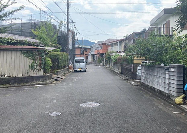 【前面道路含む現地写真_2】前面道路の幅員や歩道の有無、近隣の建物との距離感などは、実際の生活の利便性や安全性に大きく影響します。複数のアングルから前面道路の状況を確認することで、より具体的に生活イメージを描けます。