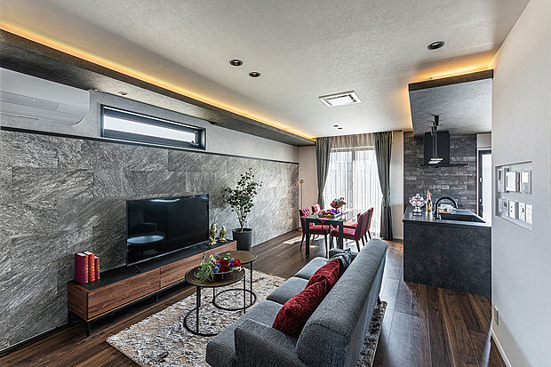 T-1／重厚感のあるアクセントクロスと間接照明が、上質な寛ぎを演出。リビングからダイニングまで直線的に繋がる開放的な設計が、家族の時間を優しく包みます。18.0帖の床暖房付き広々空間。