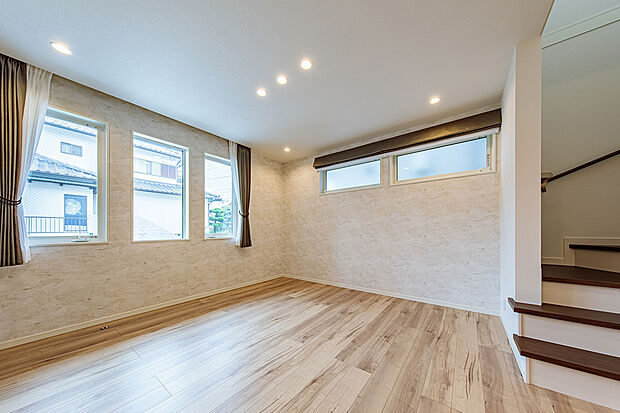 【リビング】T-1／南と東、2面の窓から降り注ぐやわらかな陽射しが、リビングを明るく心地よい空間に。そこに添えたデザインクロスが、さりげなく上質なアクセントとなり、くつろぎを感じる落ち着いた雰囲気を演出します。