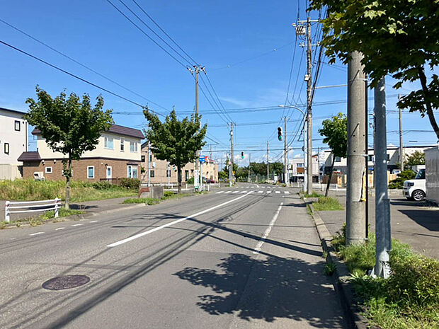 【現地写真】
歩道のある広い道路に面しており開放感がございます。最寄りのバス停まで徒歩約1分で、バスアクセスも良好です。
(2025年9月撮影）