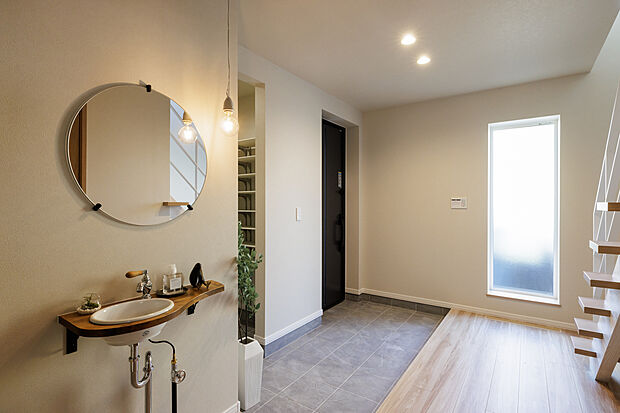 【【玄関】】木の質感が心地よく迎えてくれる玄関は、住まう人も訪れる人もほっとする温もりある空間。スムーズな動線設計で、日々の出入りも快適に。やさしい照明が落ち着いた雰囲気を演出します。（2025年7月撮影）