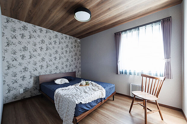 【【主寝室】】6帖の寝室は、花柄の壁が華やかさを添え、木目調の天井が温かみを演出。シンプルながらも個性を感じられる、落ち着いてくつろげる空間です。（2025年10月撮影）