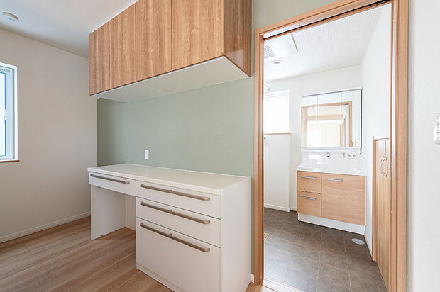 【【キッチン】】背面にはたっぷり収納を備え、使いやすさ抜群のキッチン。淡いグリーンのアクセントウォールが空間にやさしい彩りを添え、毎日の料理が楽しくなるかわいらしい雰囲気です。(2025年11月撮影）