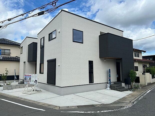 【1号地/外観写真】
ホワイト×ブラックのツートンカラーでスタイリッシュな外観。玄関ポーチの前に壁が設けられ、外から室内が見えにくい設計です。/2025年9月撮影