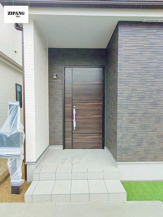 【断熱玄関ドア】断熱性能にとって開口部の玄関はとても大事です。雨にぬれずに郵便物をとることができるポスト、テレビカメラ付きのインターホンがあります。 シックな大き目の玄関ドアです。