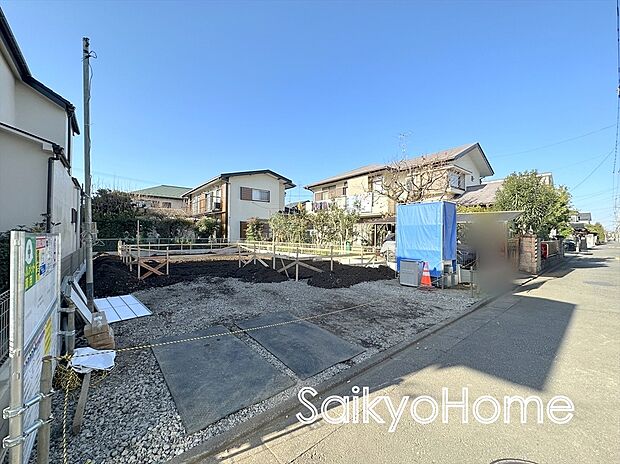 【現地外観】周囲にはスーパーをはじめとした買い物施設も揃っています。住みやすさと利便性を兼ね備えた環境です。2026年2月下旬の完成を目指しています。