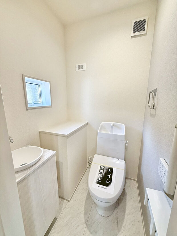【【2階トイレ ｜ 1号棟】】2階トイレはセカンドサニタリー付きシンプルな取手レスデザインのキャビネット。扉はプッシュオープン式扉。キャビネットにはタオルやハンドソープを収納できます。
