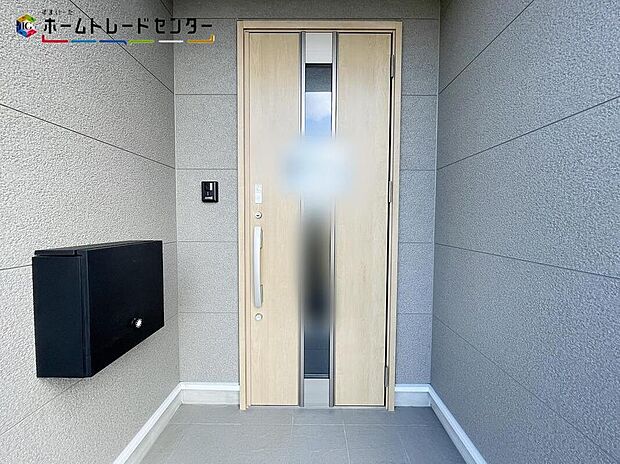【玄関】2号棟
玄関ポーチには屋根がついているので雨でも玄関前で濡れずにお出かけ準備が出来ます。セキュリティを高められるTVモニター付きインターフォンが標準装備です!