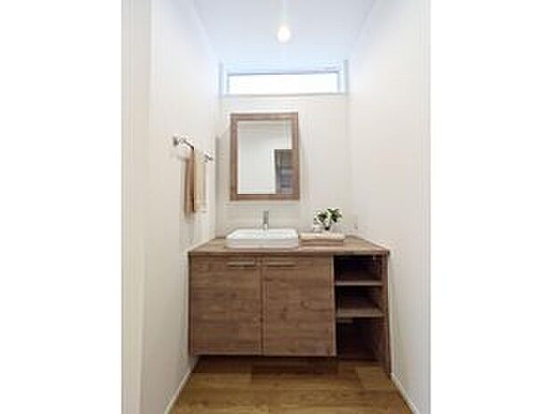 【洗面台】木目調のキャビネットタイプは、側面や棚板まで木目で統一されていて、まるで家具のような一体感があります。
広めのカウンターは、入浴後の着替えを置いたりするのに十分なスペースがあります！