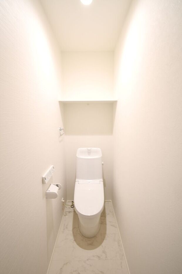 【(3)号棟 トイレ】温水洗浄便座トイレ。新素材により、気になる便座もサッとひとふきでキレイになります。※施工事例です。実際の建物とは異なります。