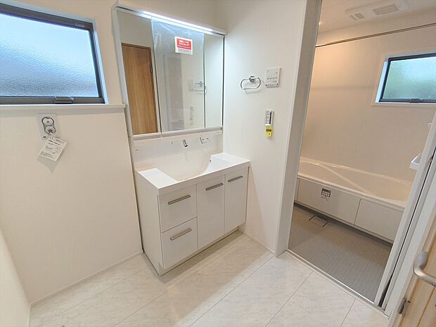 【洗面所】大きな三面鏡がついた洗面化粧台。鏡の裏にも収納があり洗面台がすっきりと片付きます。朝の身支度にも大変便利です。