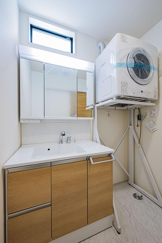 【1号棟:洗面室　】ガス衣類乾燥機標準設置。リース設置ではないので、毎月のガス料金にガス乾燥機の代金が上乗せされることはありません。