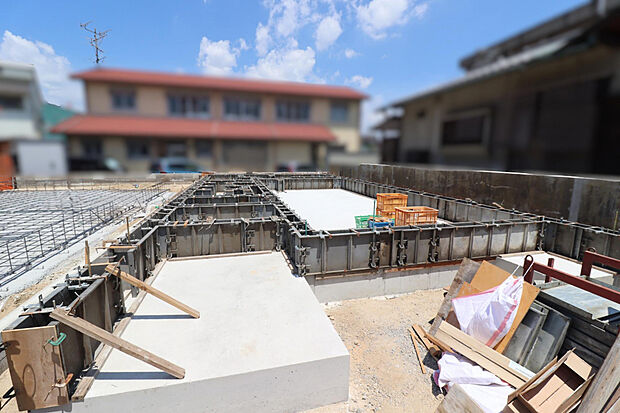 【【現地写真:基礎工事中】】リビングにはアクセントクロス(グラビオエッジ)を採用。ポップアップ天井や折上天井など、空間にメリハリや開放感を演出し、ホテルライクな空間に。
