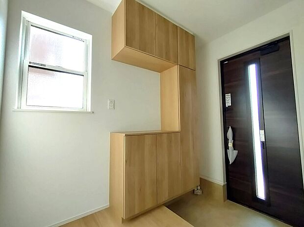 【玄関(2号地)】落ち着いた木目の収納と採光を取り入れる玄関ドアが、明るく迎え入れてくれる空間。収納力も十分で、日々の出入りが快適に整う、使い勝手の良い玄関です♪