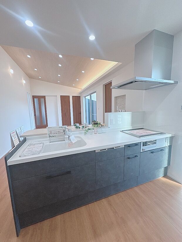 【【新田広芝3-16】キッチン】ブラックの扉でシックに仕上げたキッチン。背面の壁は落ち着いたグレー系のクロスで、全体をスタイリッシュにまとめています。