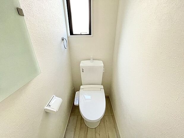 【トイレ】2号棟 清潔感あふれる白を基調とした空間に、心地よい自然光が優しく広がる、落ち着いた時間が流れるプライベートスペース