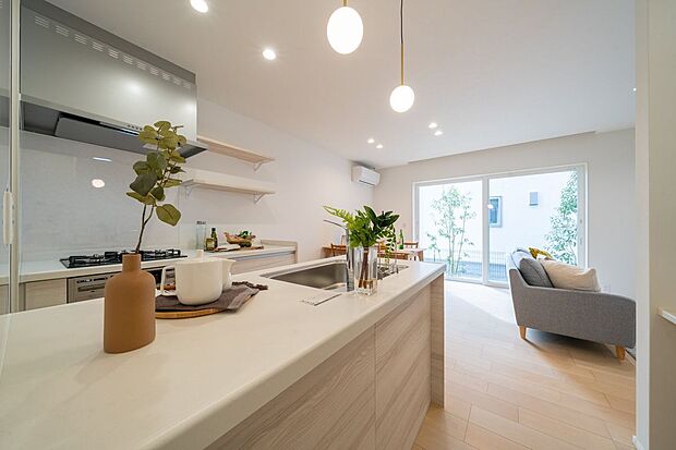 【キッチン】■1号地キッチン　ダウン照明が印象的なキッチン。背面にはウォールラックを備え、調味料や調理道具をすっきり収納でき、作業動線も効率的です。