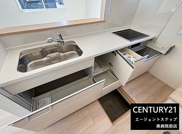 シンプルなデザインのキッチンです。収納スペースが多く整理整頓がしやすいです。広々とした作業台で使い勝手にも配慮されています。IHクッキングヒーターも設置されています。明るい窓があり開放感があります。